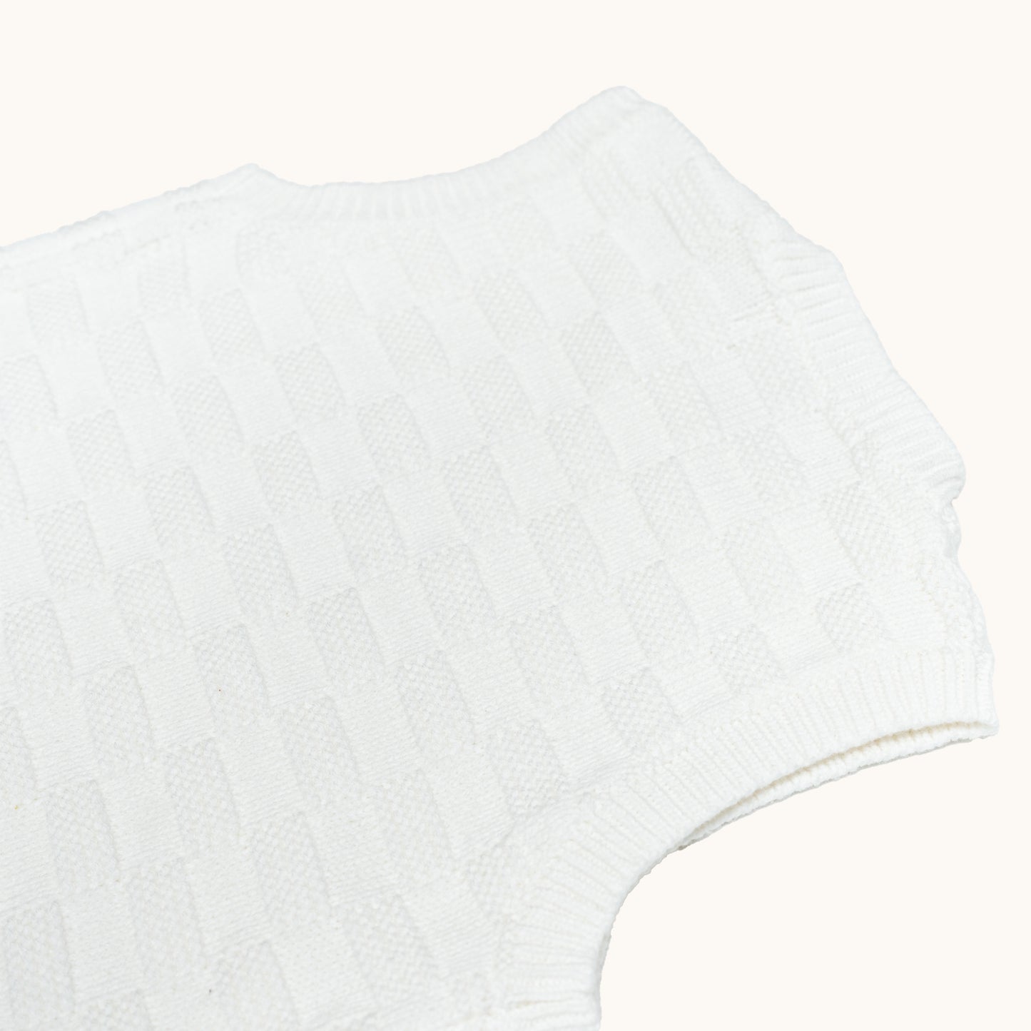 KNITTED BUTTONED WAISTCOAT - CREAM; 100% Organic Cotton; Waistcoat made from GOTS-certified organic cotton; Wooden button at shoulder for easy dressing; Rib finish at neck, hem and cuffs; Relaxed fit.