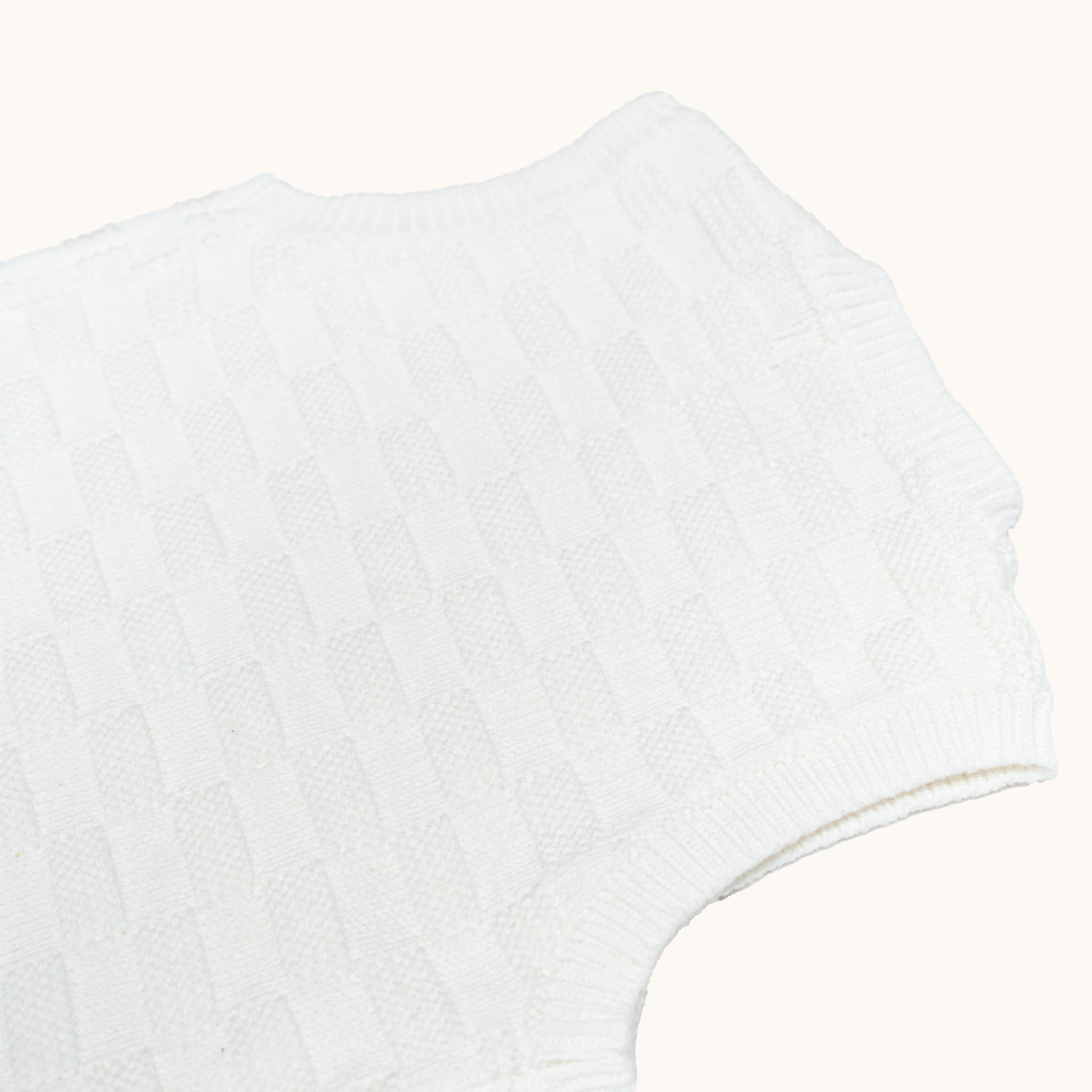 KNITTED BUTTONED WAISTCOAT - CREAM; 100% Organic Cotton; Waistcoat made from GOTS-certified organic cotton; Wooden button at shoulder for easy dressing; Rib finish at neck, hem and cuffs; Relaxed fit.