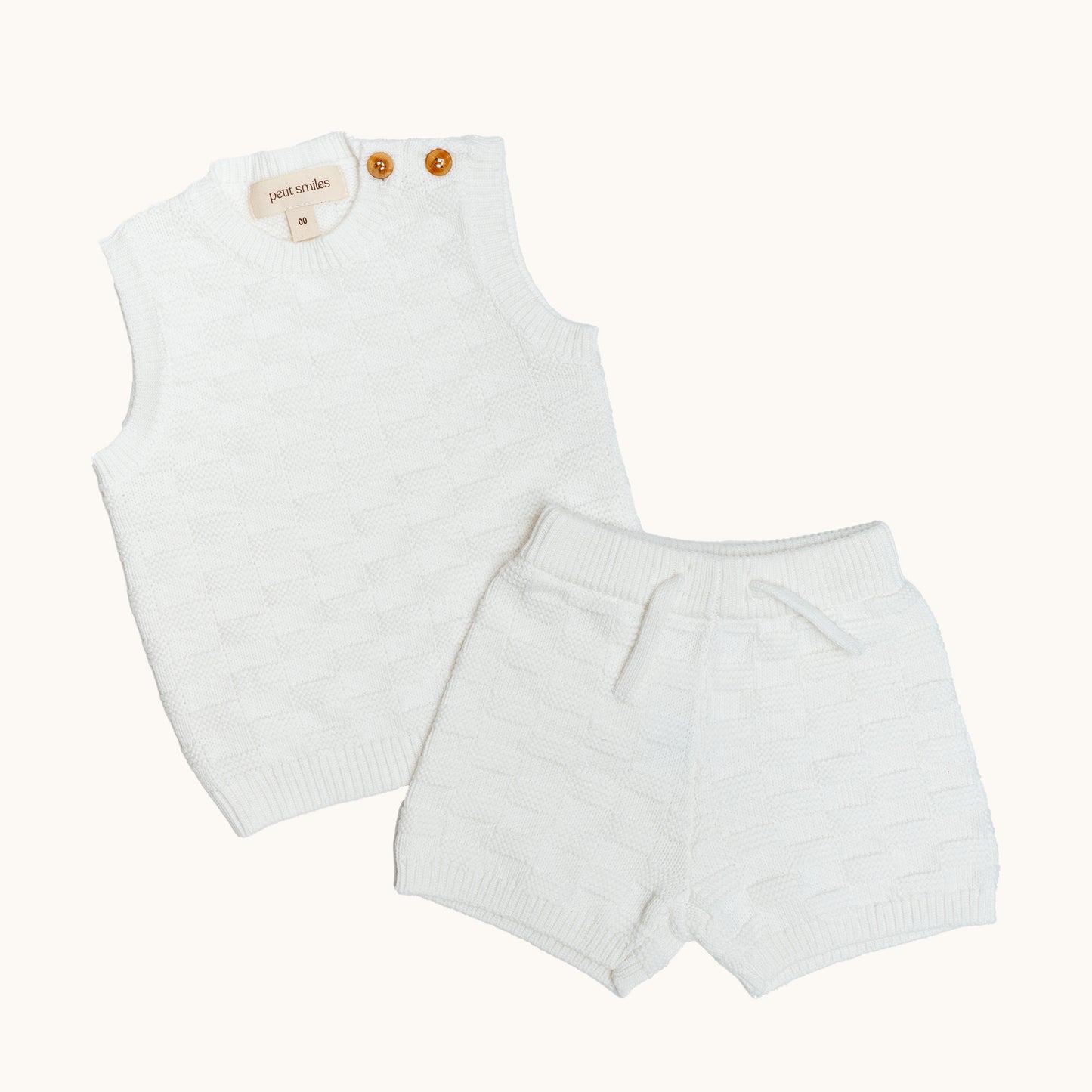 KNITTED BUTTONED WAISTCOAT - CREAM; 100% Organic Cotton; Waistcoat made from GOTS-certified organic cotton; Wooden button at shoulder for easy dressing; Rib finish at neck, hem and cuffs; Relaxed fit.