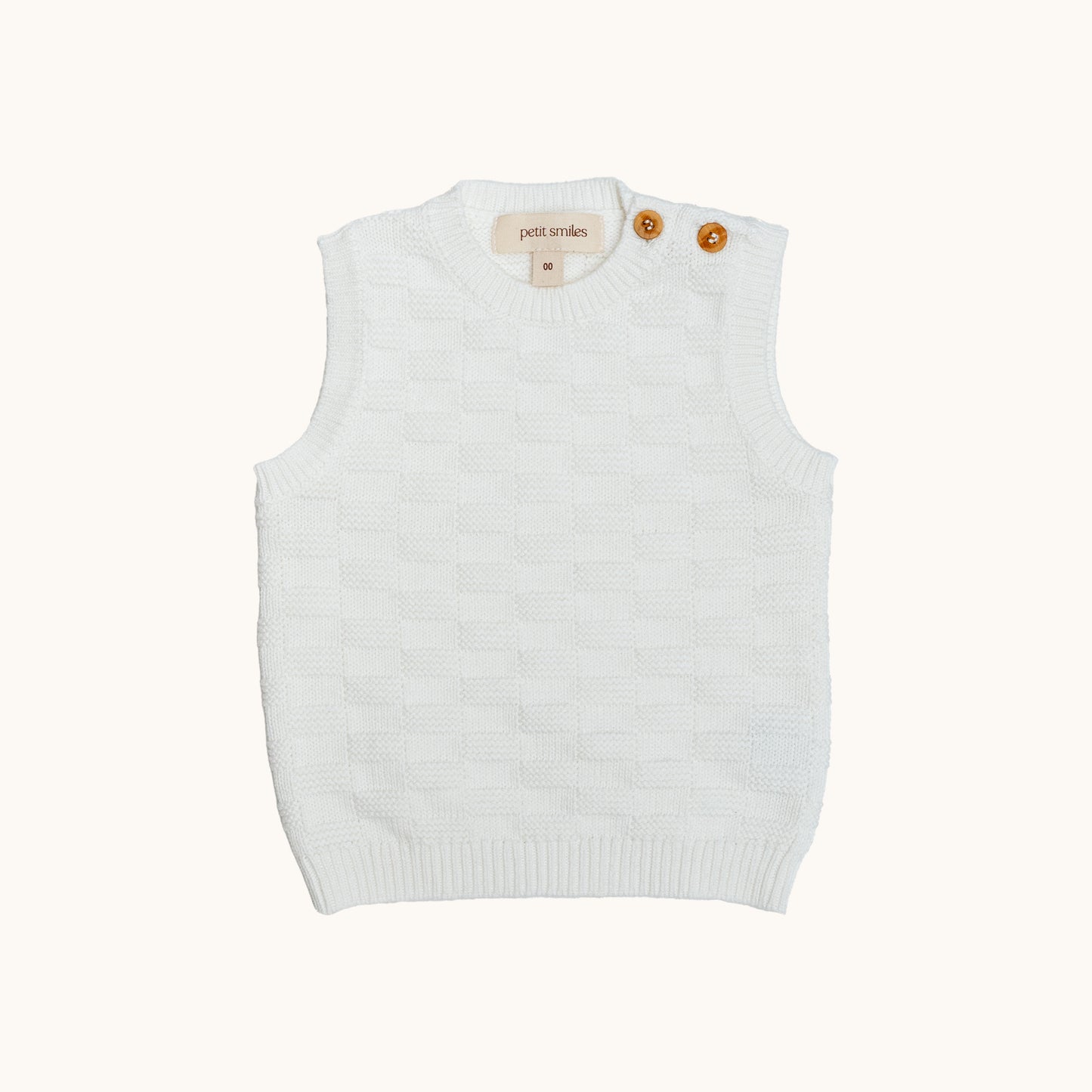 KNITTED BUTTONED WAISTCOAT - CREAM; 100% Organic Cotton; Waistcoat made from GOTS-certified organic cotton; Wooden button at shoulder for easy dressing; Rib finish at neck, hem and cuffs; Relaxed fit.